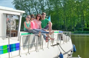 Family vacation, summer holiday travel on barge boat in canal, happy kids and parents having fun on river cruise trip in houseboat in France